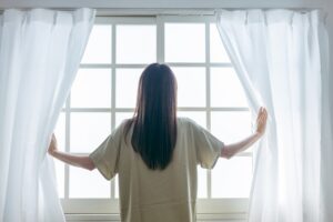 窓を開ける女性